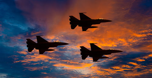 fighter jet planes flying at sunset